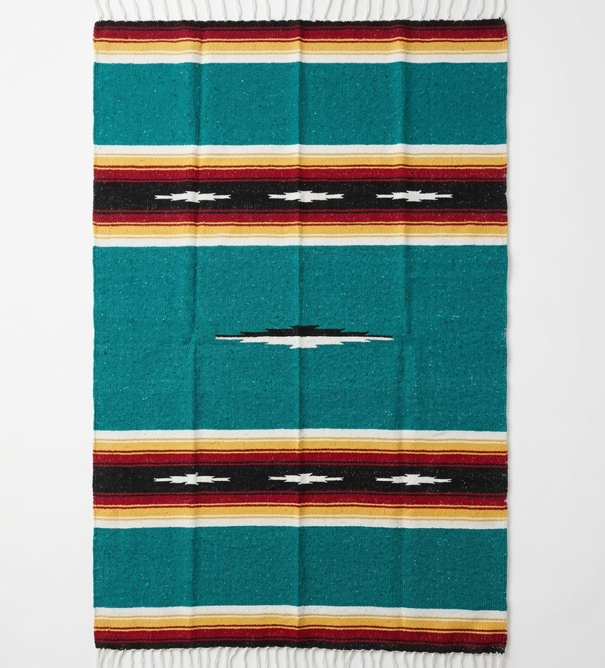Colorful woven blanket with a geometric pattern on a white background